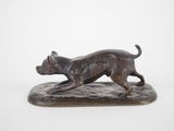 an image of a bronze statue of a dog running on a base