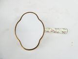 an old mirror with a gold rim on a white surface
