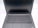the laptop is open on a white surface with a red button on the keyboard