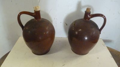 deux vases marron posés sur une table en bois