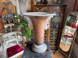 a large vase sitting on top of a pedestal in a room