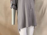 the mannequin is wearing a gray shirt and white pants