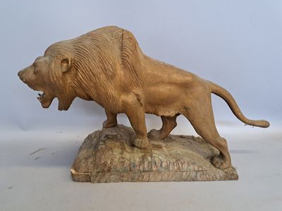 statue of a lion on a rock on a white background