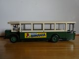 un petit bus en jouet posé sur une table en bois