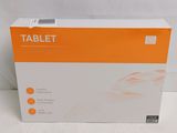 une boîte orange et blanche contenant une tablette, posée sur une surface blanche