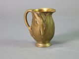 a gold vase that is sitting on a table