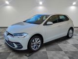 une Volkswagen Polo blanche garée dans une pièce au sol carrelé