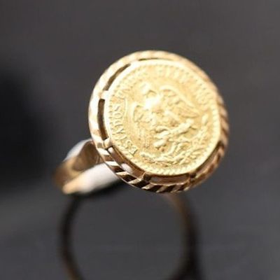 Gros plan sur une bague ornée d'une pièce d'or