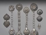 Des bracelets et des broches en argent sont présentés sur un fond blanc