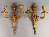 pair of antique brass wall sconces on a white wall