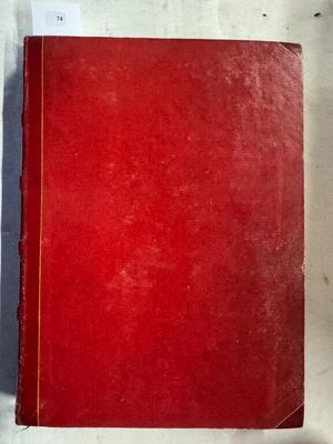 un vieux livre rouge posé sur une table blanche