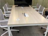tables and chairs in a conference room with a flat screen tv on the wall