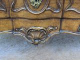 a wooden chest of drawers with ornate carvings on it