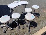 quatre tabourets et une table au milieu d'un parking