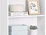 a white bookcase with baskets on top of it