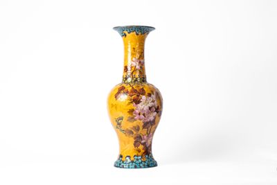 un vase jaune orné d'un motif floral
