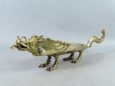 une image représentant une plaque en laiton ornée d'un dragon