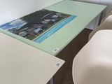 a glass table with a picture on it in the corner of a room