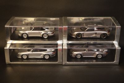 three silver die cast cars in clear boxes on a black surface