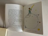an open book with a drawing of a boy on a globe