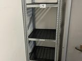 une étagère en métal dans une pièce où se trouve un réfrigérateur