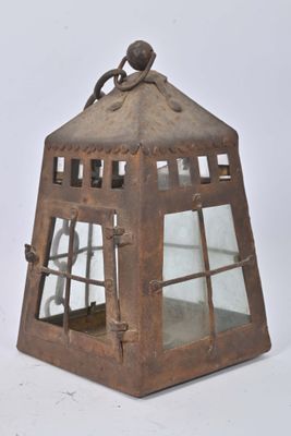 a small metal lantern with a bird on top of it