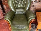 a green leather chair in a living room with a rug