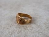 an image of a gold ring on a white surface