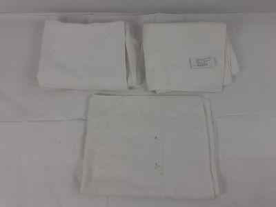 deux serviettes blanches sur un lit recouvert d'un drap blanc