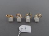 four rings and a tag on a table with a price tag