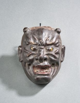 un masque accroché au mur d'une pièce sur fond bleu clair