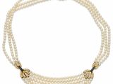 un collier de perles à trois rangs muni d'un fermoir en or