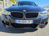 the front view of a black bmw car parked in a parking lot