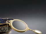 une image représentant un bol bleu et blanc orné d'un miroir