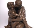 statue en bronze représentant un garçon et une fille enlacés sur fond blanc