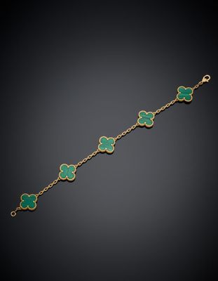 un bracelet en or 18 carats orné de breloques en forme de trèfle en émail vert