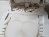 a dirty white dishwasher with a metal bowl on it