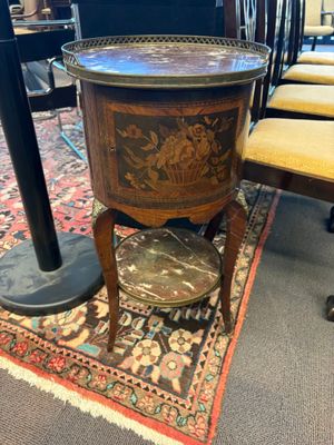 une petite table sur laquelle se trouve une horloge, dans une pièce