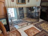 une pièce avec beaucoup de tapis et un miroir accroché au mur