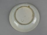 a white plate with a brown rim sitting on a table