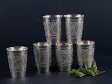 six silver cups with leaves on them and a sprig of mint