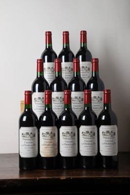 Des bouteilles de vin rouge sont posées sur une table devant un mur blanc.