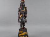 an old wooden statue of a man with a hat on his head