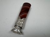 an antique silver and red glass cigarette holder on a white surface