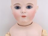 an image of a doll that is sitting on a white surface