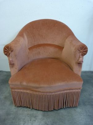 une image représentant une chaise marron sur laquelle est posée une jupe plissée