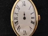 a gold wrist watch with roman numerals on the face
