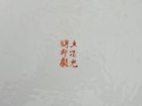 a close up of a white plate with a red design on it