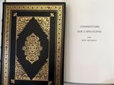 an open book with a gold and black cover sitting on top of a white table