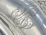 a silver plate that has a monogram on it